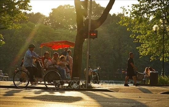 Tourists experience a cyclo ride around Hoan Kiem Lake. Photo: Khanh Hoa/VNA